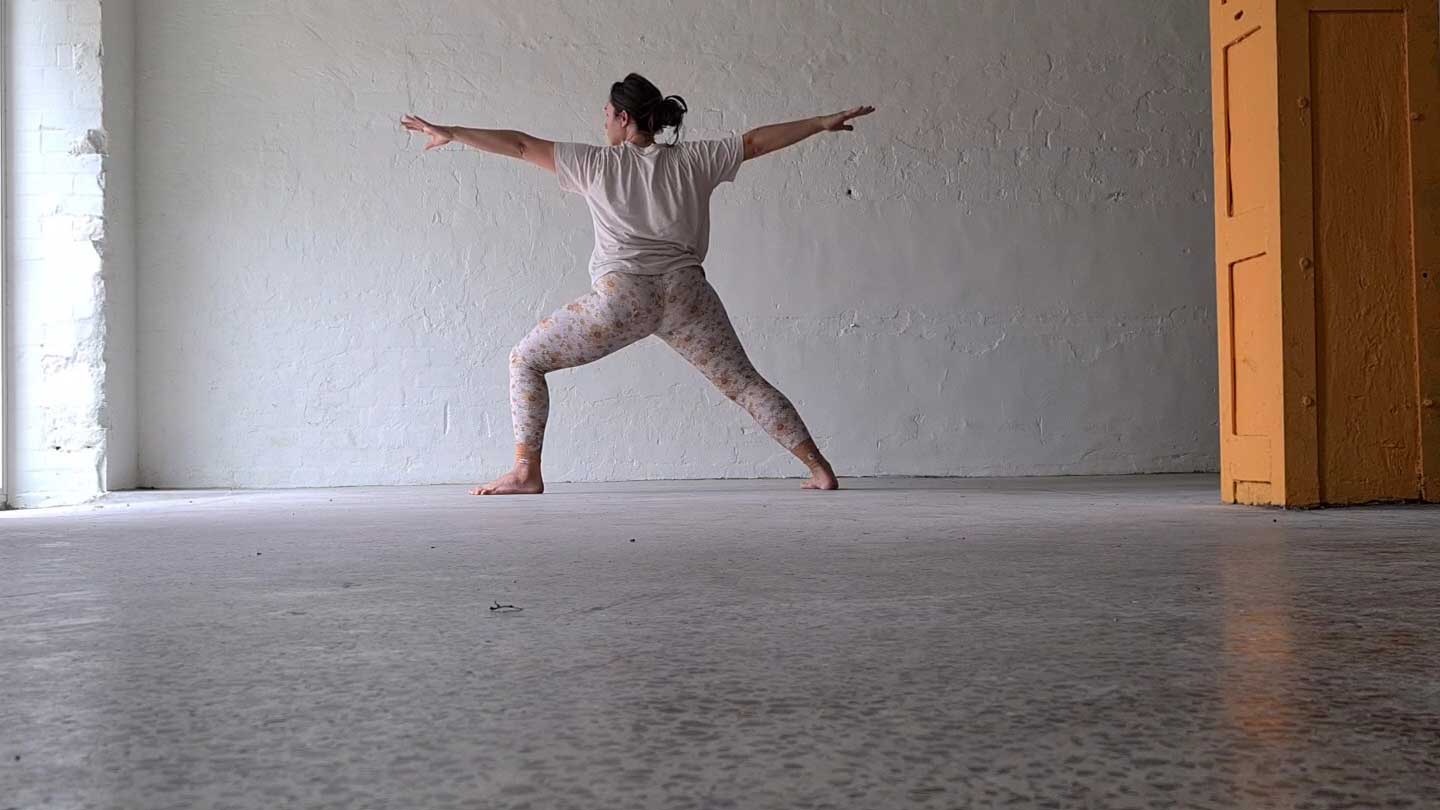 lady standing in warrior yoga pose